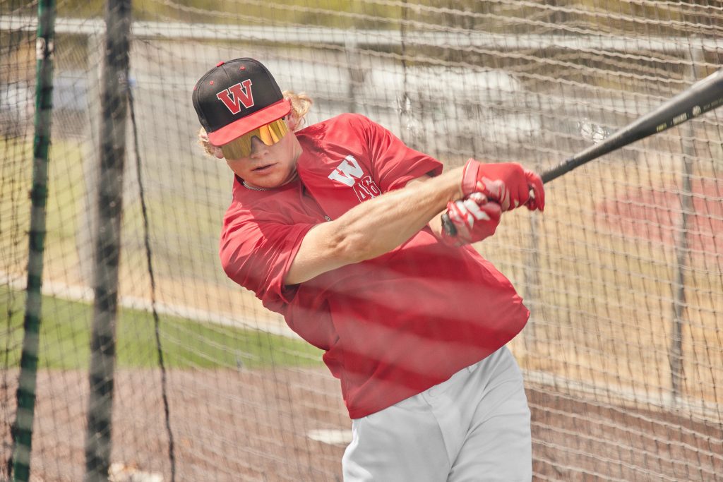 Baseball player wearing Sport-Tek JST489 1/2-Zip Short Sleeve Jacket, perfect for warm-ups and game-day comfort