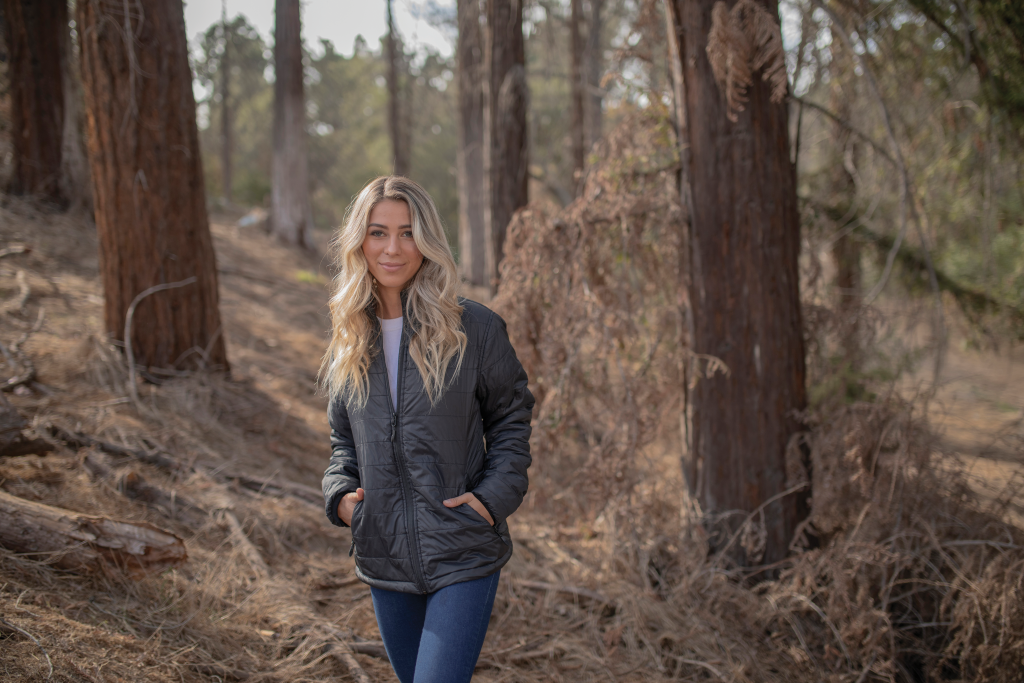 Trekker in camouflage outdoor jacket. A forest trekking adventure.