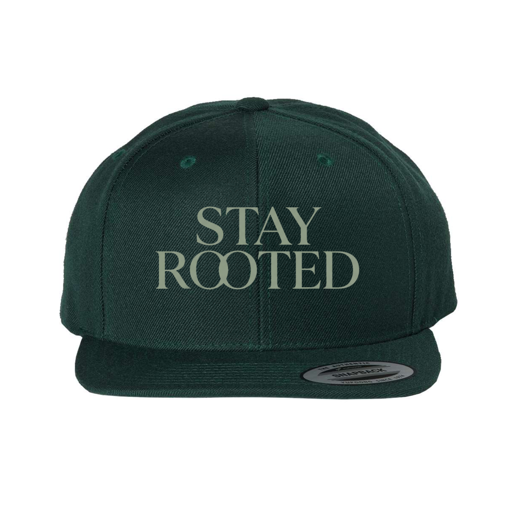 Dark green YP Classics Premium Snapback (6089) with “STAY ROOTED” in bold light lettering on the front and a flat visor, modern stylish cap.