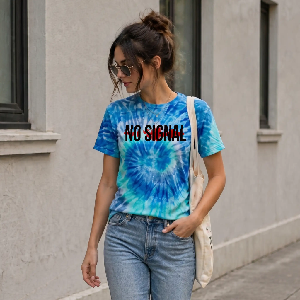 Woman wearing a blue crystal wash tie-dye “No Signal” t-shirt (1390) and sunglasses walking with a tote bag in a casual streetwear look.